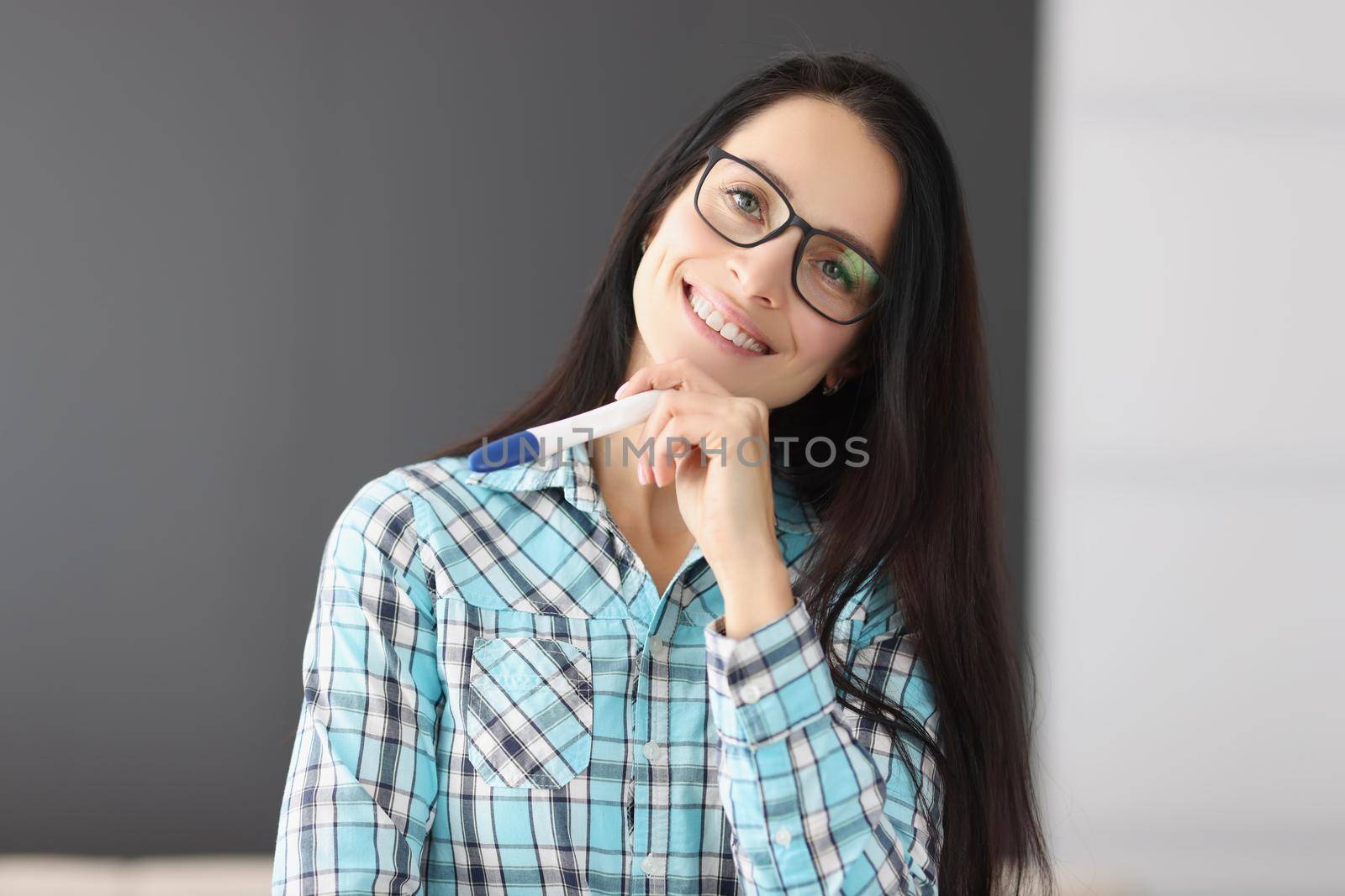 Young happy female hold pregnancy test, female got big news and smiling by kuprevich