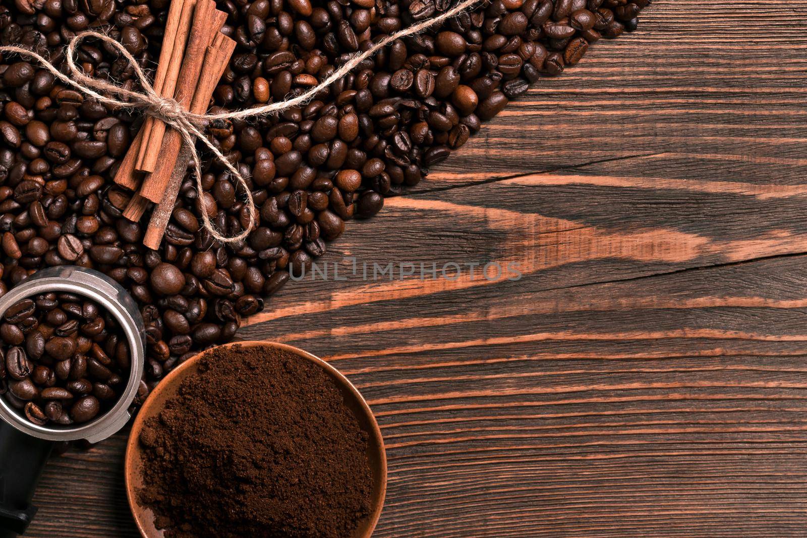 Coffee beans, cinnamon sticks and ground coffee on rustic wooden by nazarovsergey