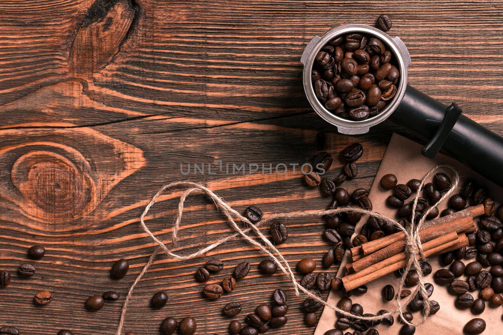 Coffee beans and cinnamon sticks on rustic wooden table, view fr by nazarovsergey