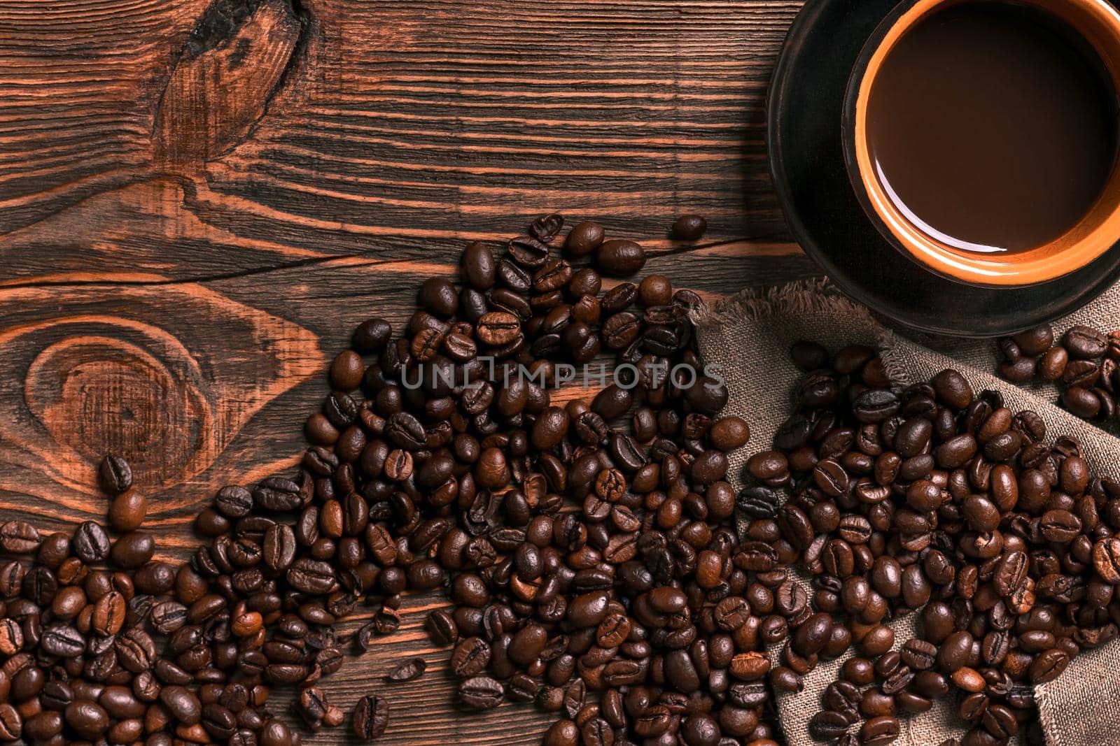 Coffee cup and beans frame on wooden table. Top view. Copy space. Still life. Mock-up. Flat lay