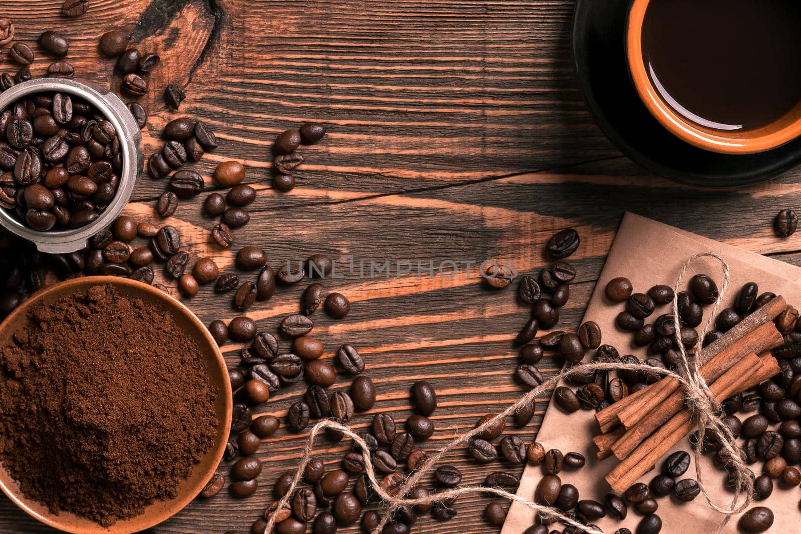 Coffee beans, ground coffee and cup of brewed coffee on rustic wooden table, view from above with space for text. Still life. Mock-up. Flat lay