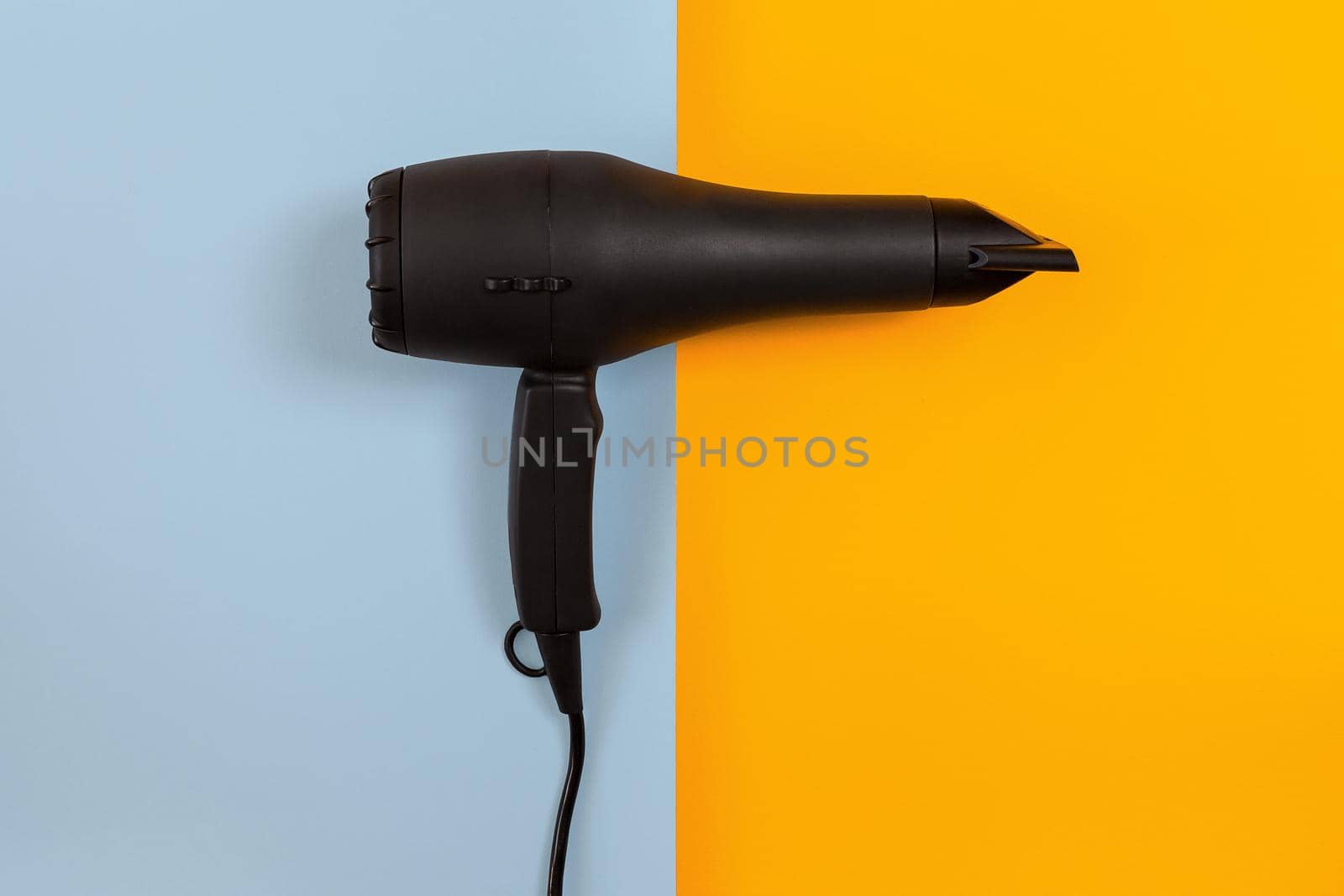 Black Hair dryer on blue and orange background by nazarovsergey