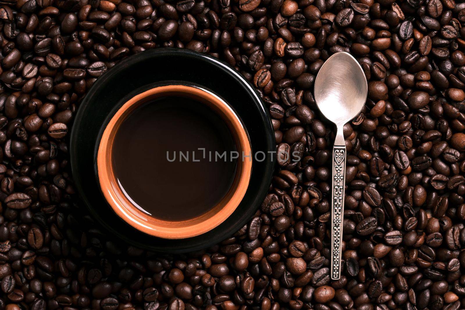 A cup of black coffee with coffee bean as background. Top view. Copy space. Still life. Mock-up. Flat lay