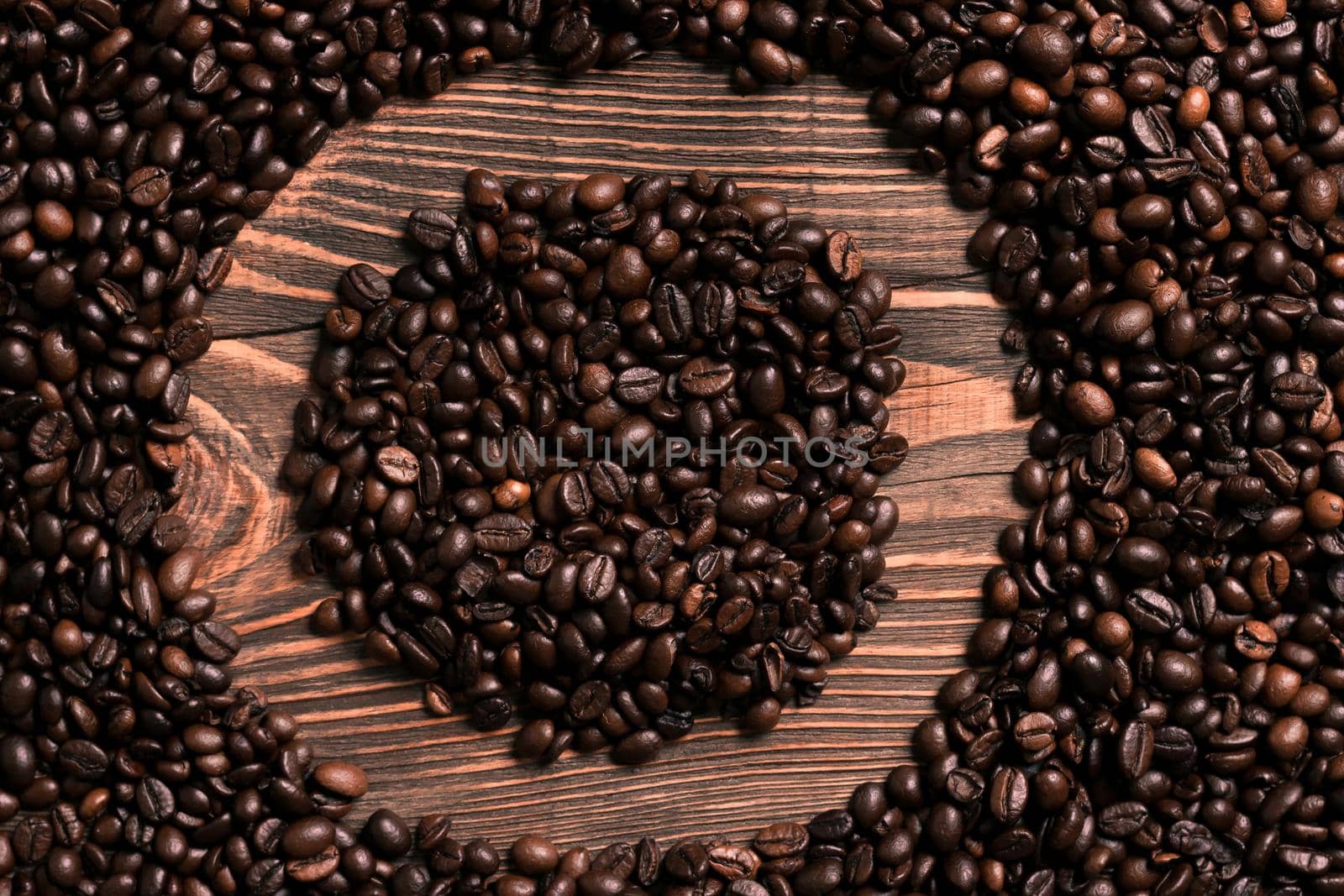Letter O inscription with coffee bean on the wooden table. Top view. Copy space. Still life. Mock-up. Flat lay