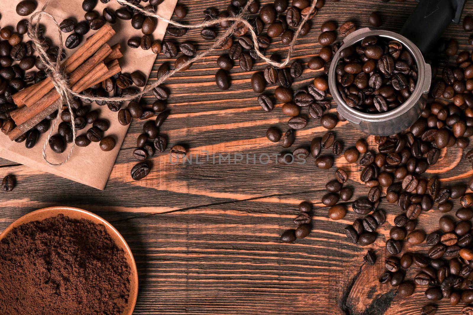 Ground coffee, coffee beans on wooden table background with cinnamon. Top view. Still life. Copy space. Flat lay.