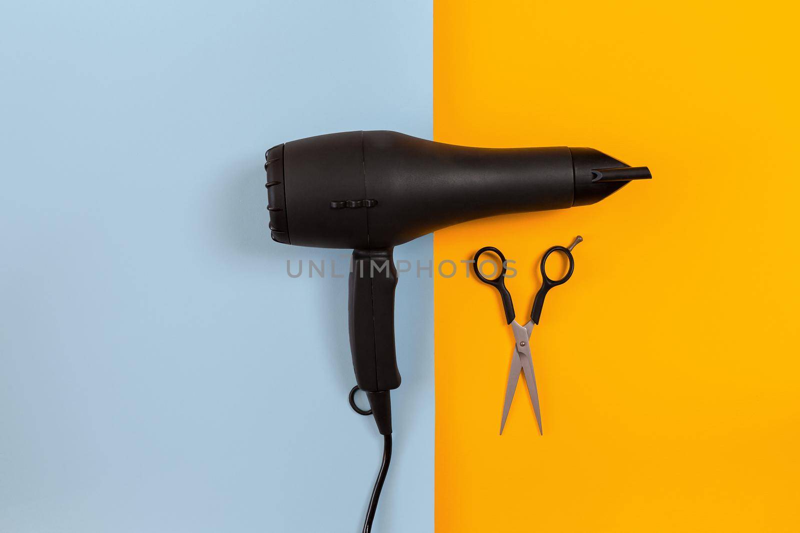 Hairdresser set with various accessories on orange and blue background. Top view. Copy space. Still life. Mock-up. Flat lay