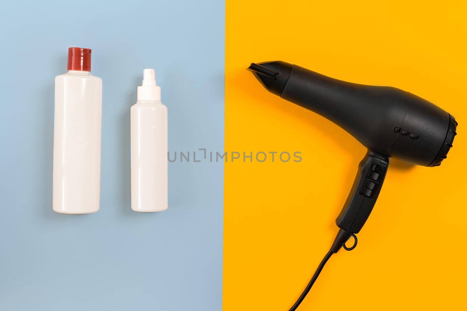 Hairdresser set with various accessories on orange and blue background. Top view. Copy space. Still life. Mock-up. Flat lay