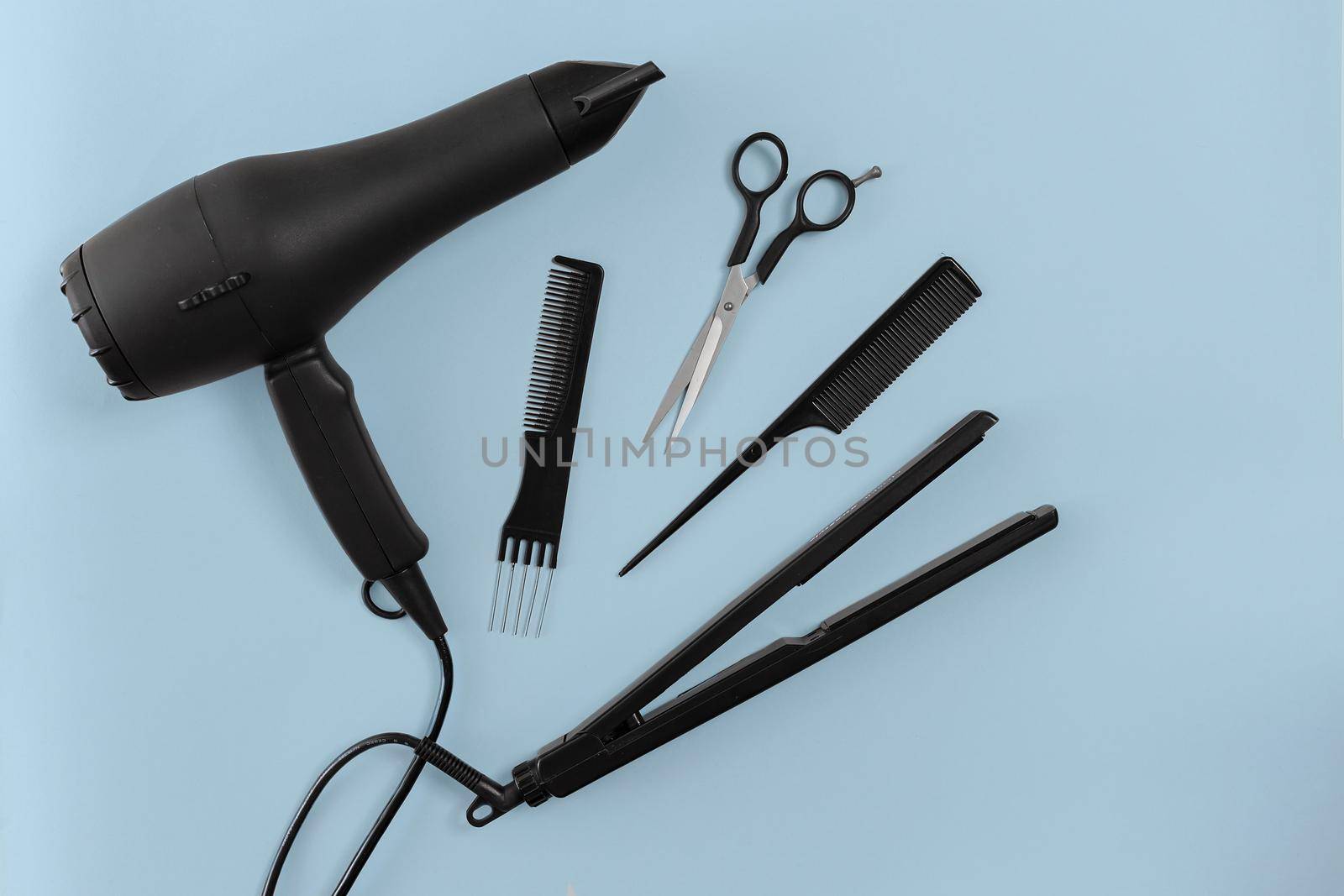 Hairdresser set with various accessories on gray background. Top view. Copy space. Still life. Mock-up. Flat lay
