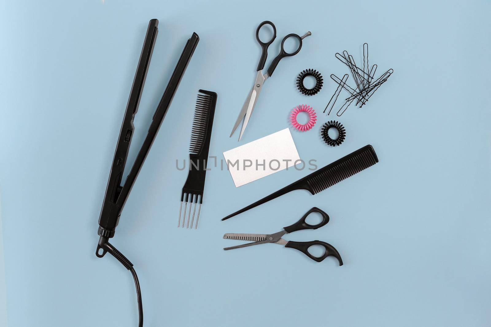 Hairdresser set with various accessories on blue background. Top view. Still life. Flat lay.