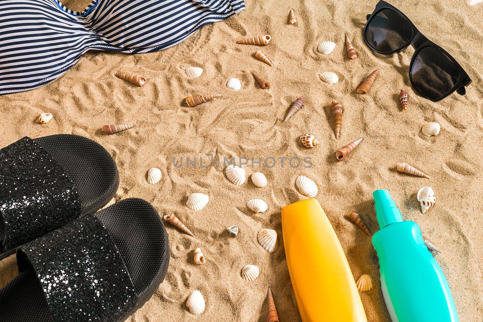 Summer bikini and accessories stylish beach set, Beach bikini summer outfit and sea sand as background, Top View, Concept. Copy space