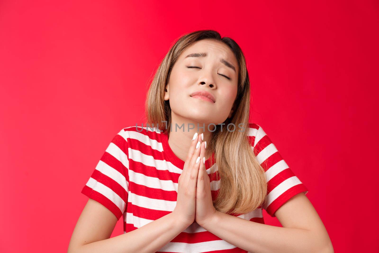Close-up silly hopeful asian girl blond hairstyle, asking god help, hold hands pray, supplicating raise head up closed eyes, making wish, anticipating miracle, pleading lord dream come true by Benzoix
