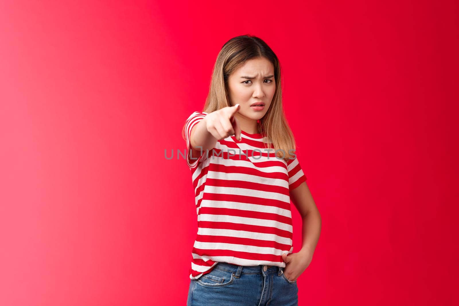 Girl plead you guilty. Upset asian blond girlfriend being cheated on pointing camera blame person make accusations, frowning disappointed and hurt, stand red background bothered offended.