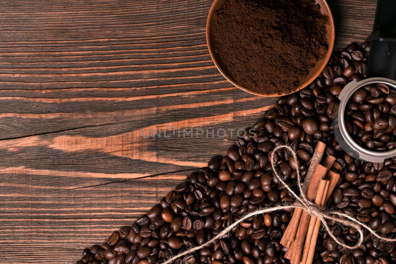 Ground coffee, coffee beans on wooden table background with cinnamon. Top view. Still life. Copy space. Flat lay.