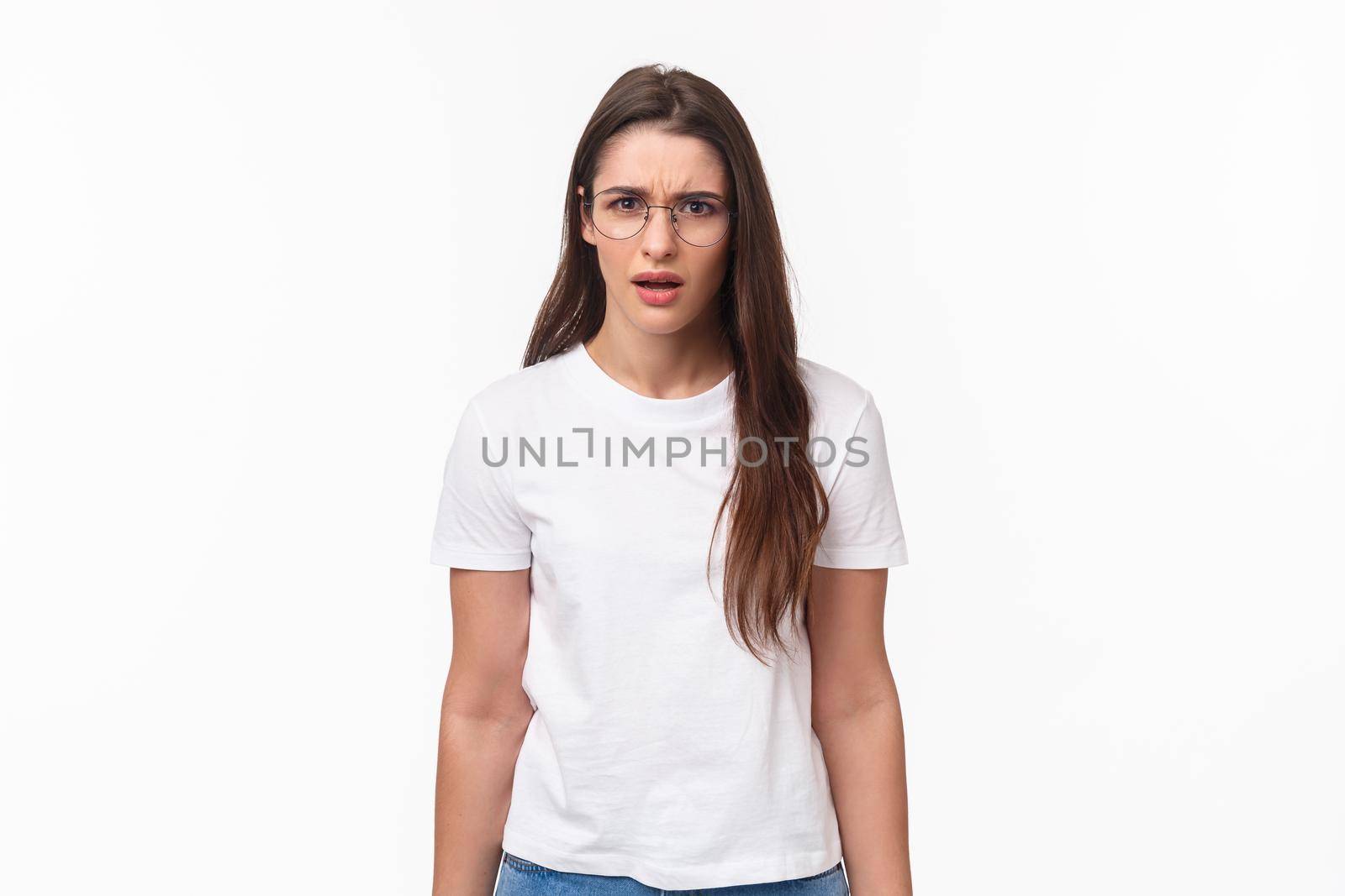 Waist-up portrait of frustrated and shocked young female coworker hear strange confession, freak out, frowning and grimaccing tensed and disappointed, dont agree and like idea, white background.