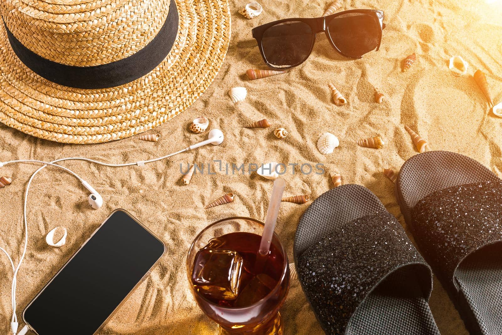 Summer beachwear, flip flops, hat, sunglasses and seashells on sand beach. by nazarovsergey