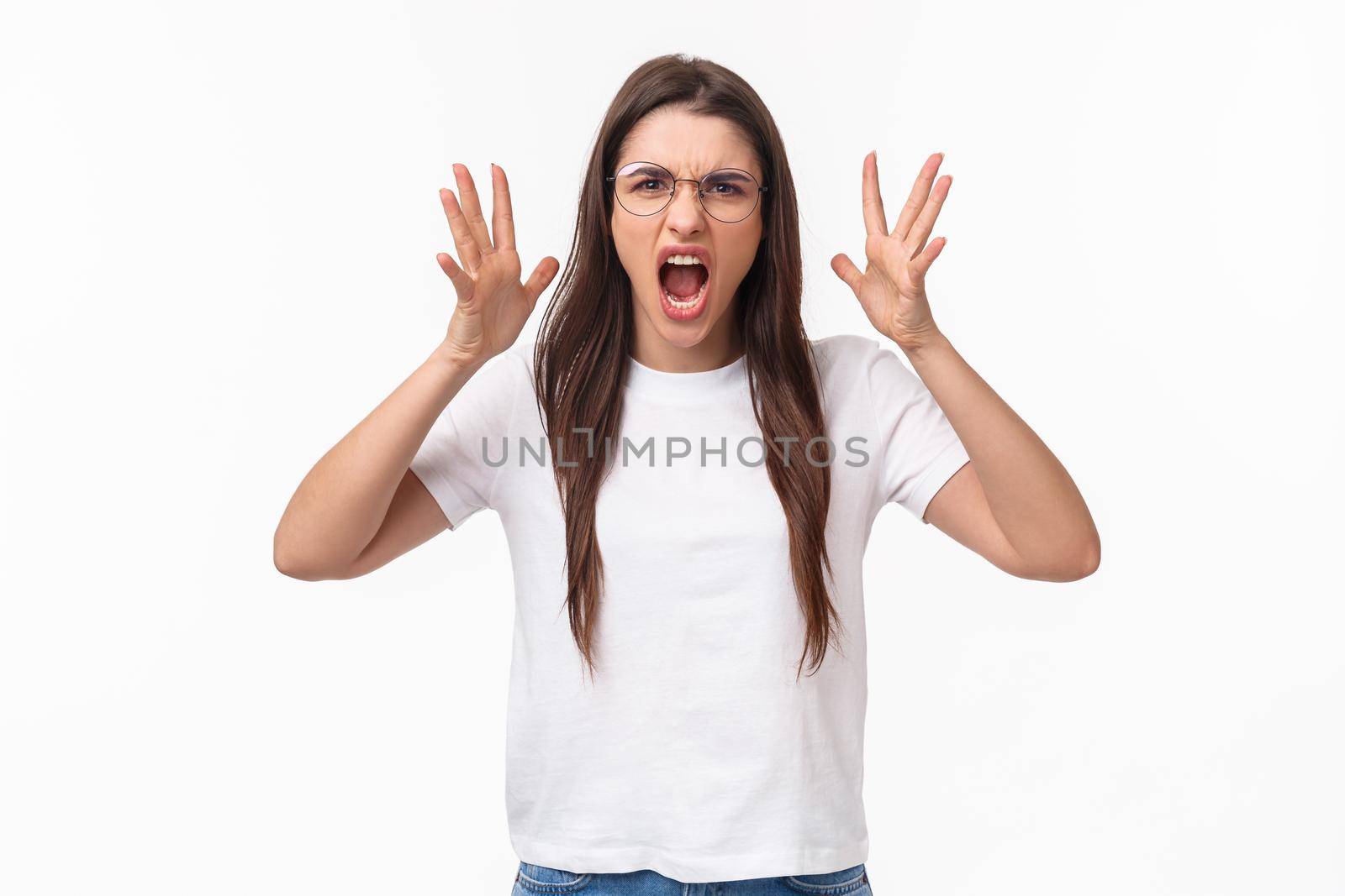 Waist-up portrait of angry, pissed-off brunette pretty girl in glasses, shouting, blaming partner for cheating on her, shaking hands and screaming, having confrontation, frowning aggressive by Benzoix