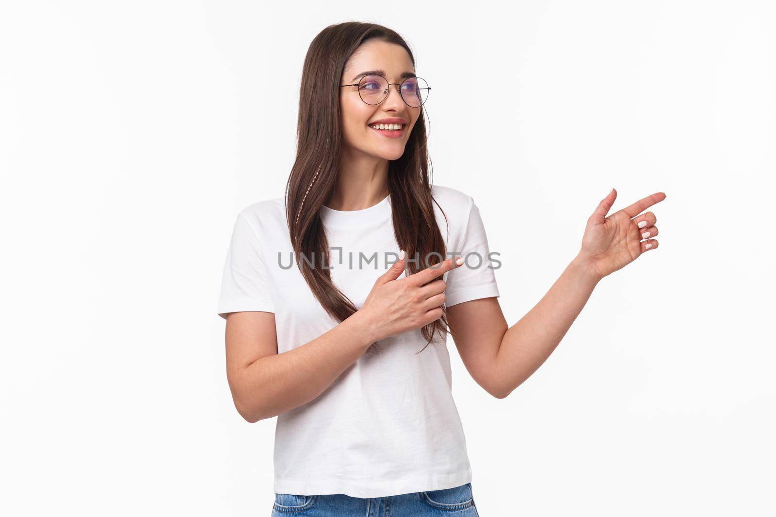 Waist-up portrait of amused, pleased good-looking brunette girl in glasses, looking and pointing fingers right at something good, found useful product or link, white background.