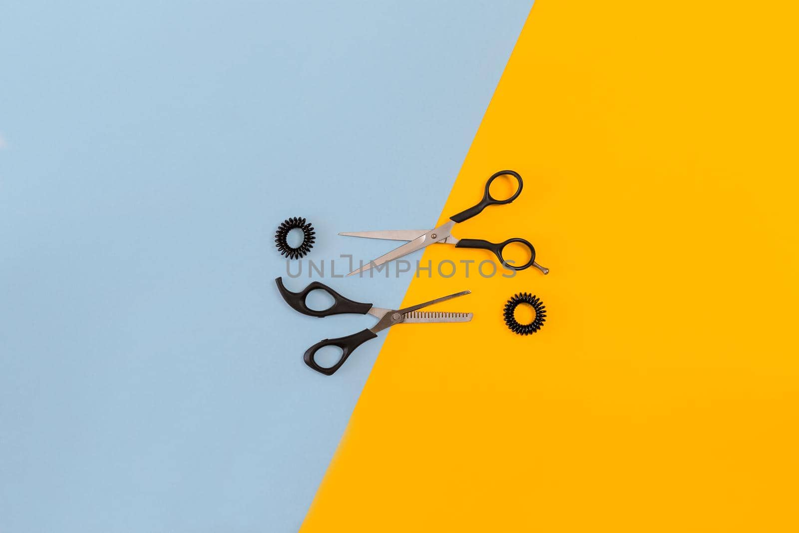 Scissors on the color blue, yellow paper background. Top view. Copy space. Still life. Mock-up. Flat lay