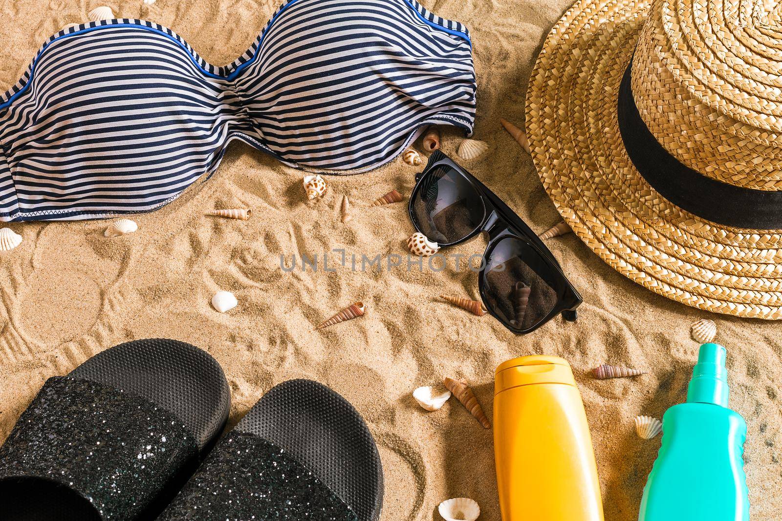 Summer bikini and accessories stylish beach set, Beach bikini summer outfit and sea sand as background, Top View, Concept. Copy space