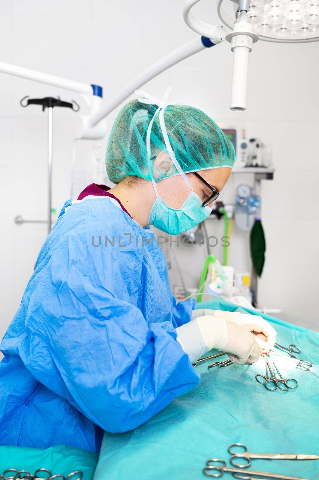 Close-up portrait of female surgeon wearing sterile clothing operating at operating room. by HERRAEZ