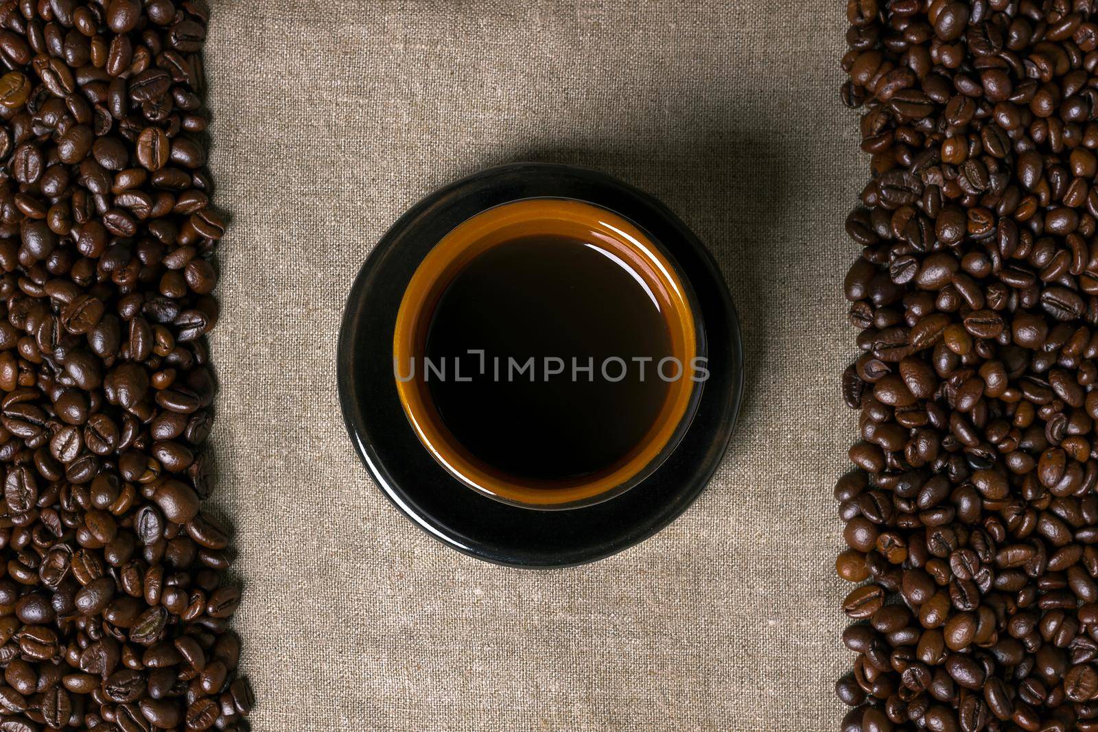 Coffee beans and Coffee cup on a burlap background. Top view. Copy space. Still life. Mock-up. Flat lay