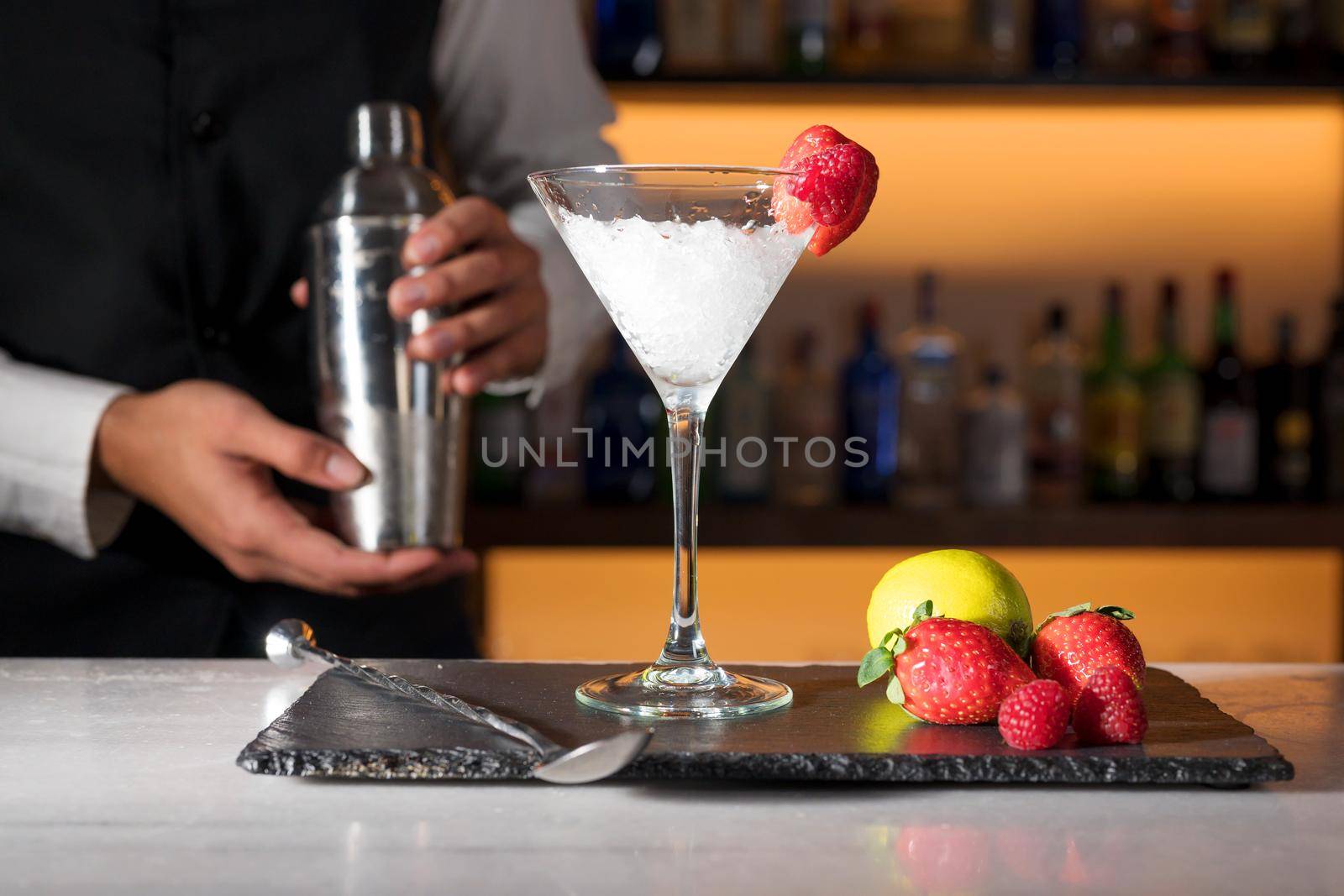 Expert barman is making cocktail at night club. High quality photography.