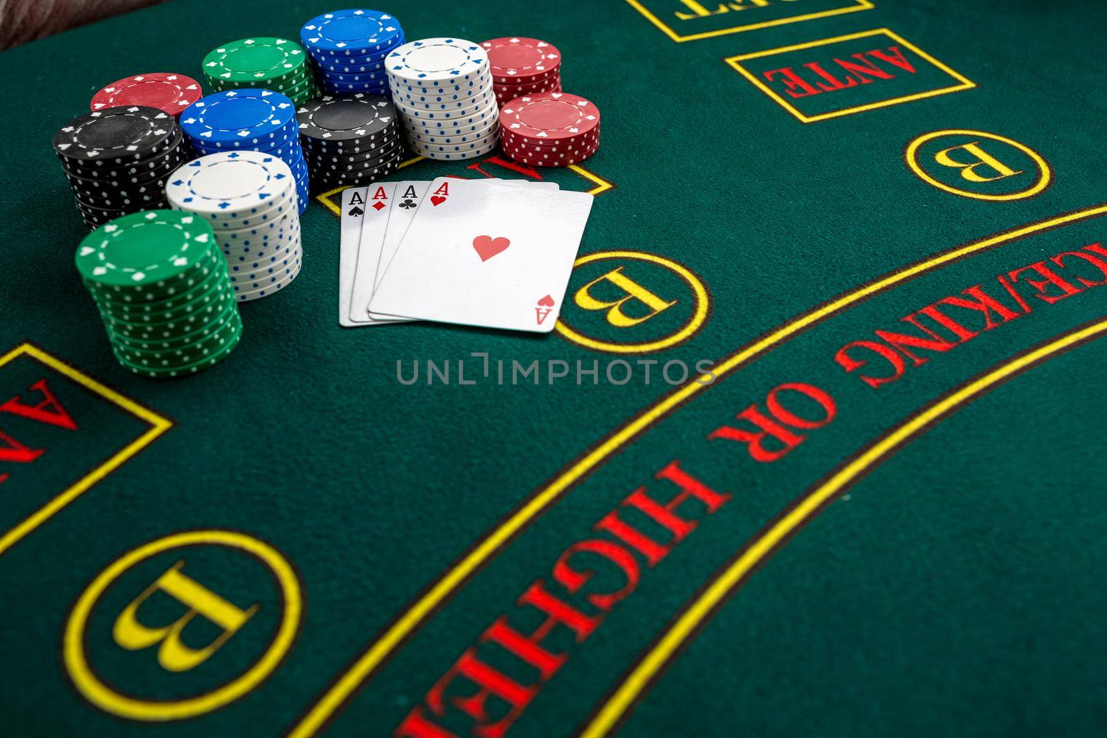 Poker play. Chips and cards on the green table