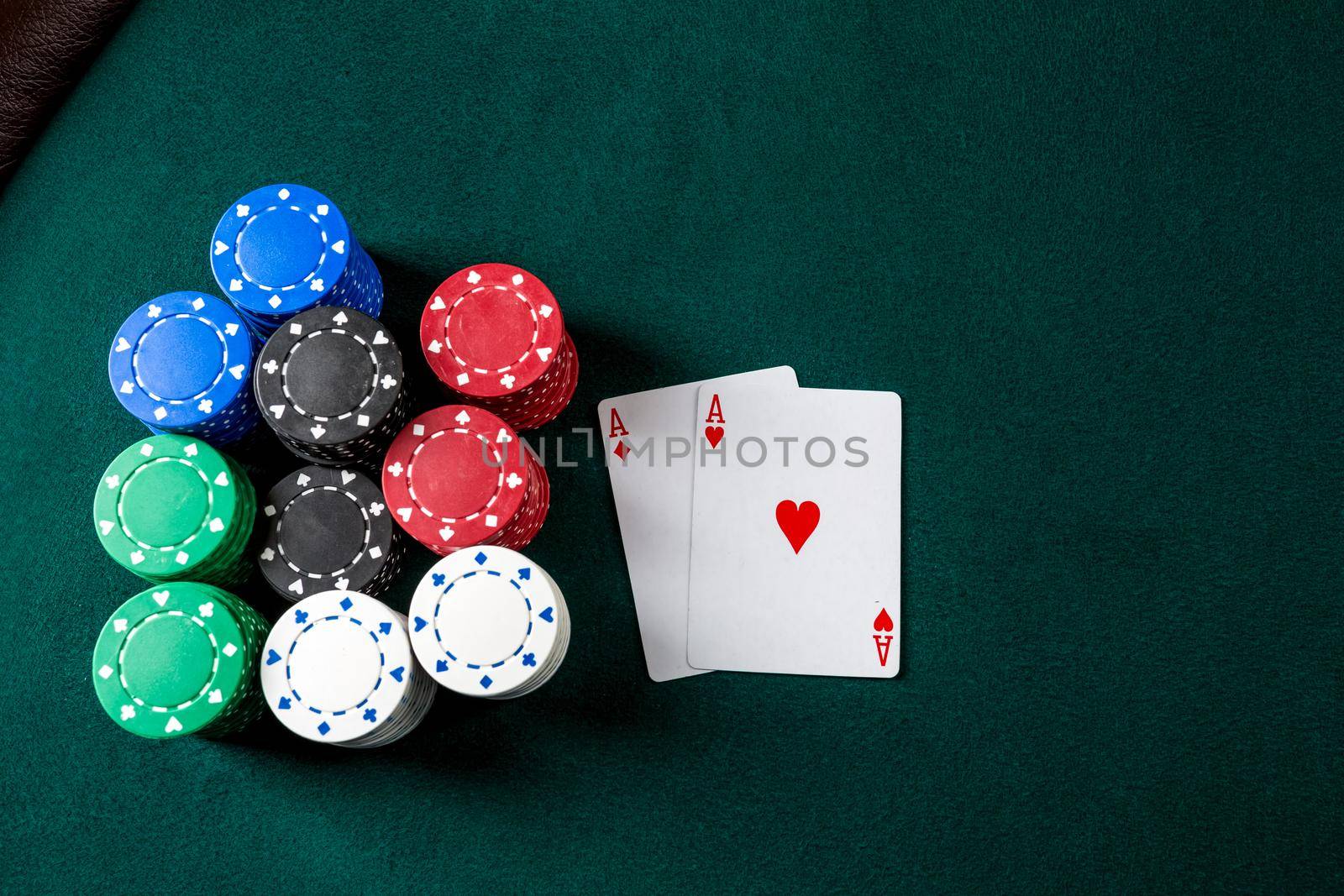 Poker play. Chips and cards on the green table