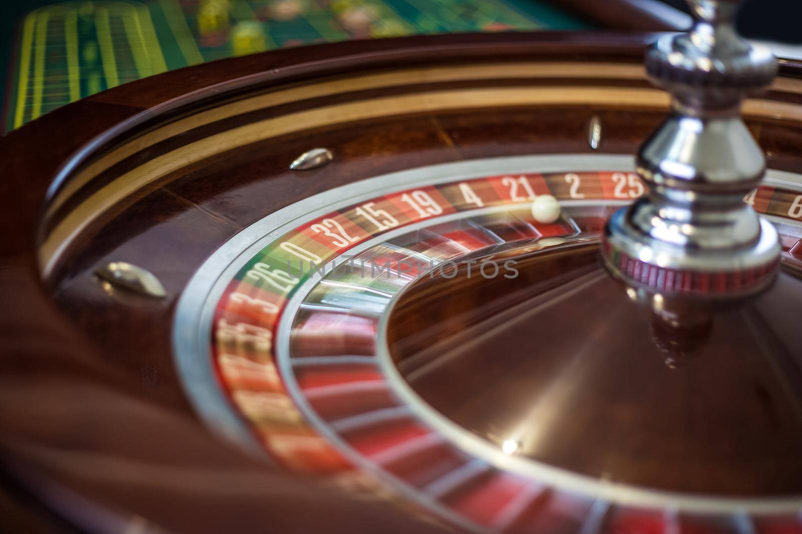 Classic casino roulette wheel with red sector twenty-one 21 and white ball. Close up