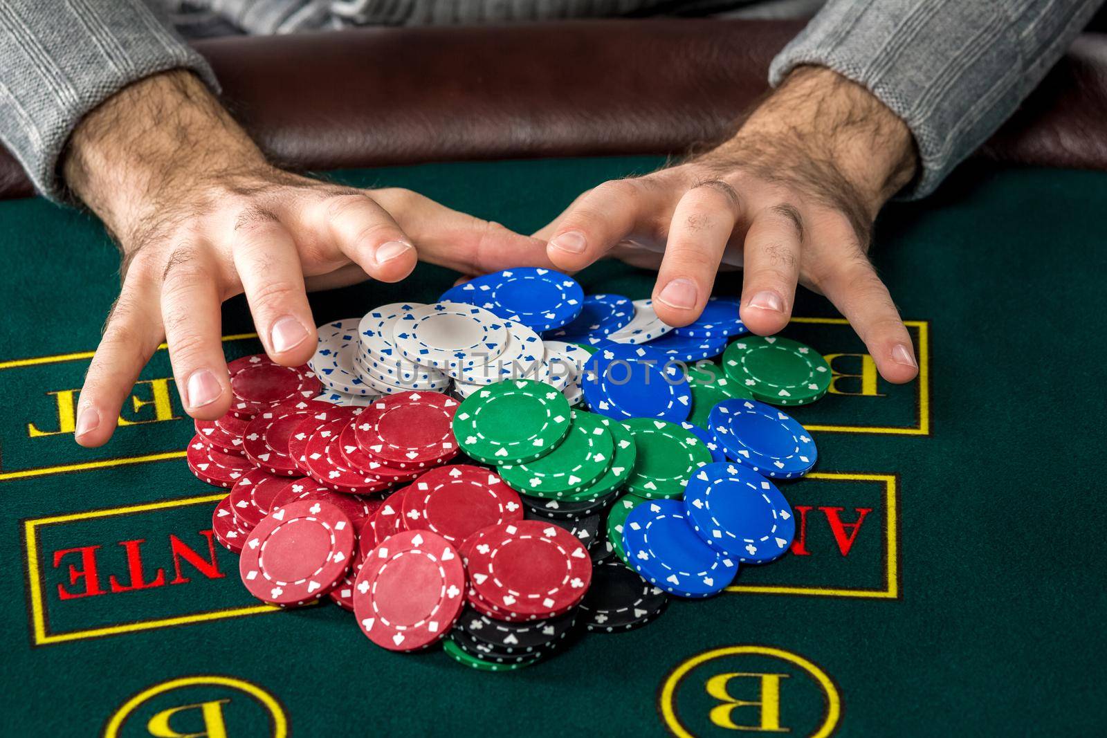 Poker play. Chips on the green table. chips in male hands