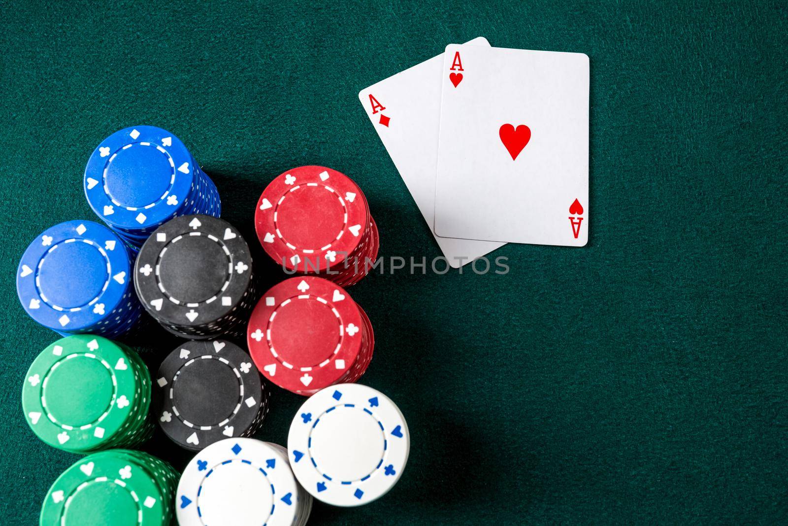 Poker play. Chips and cards on the green table