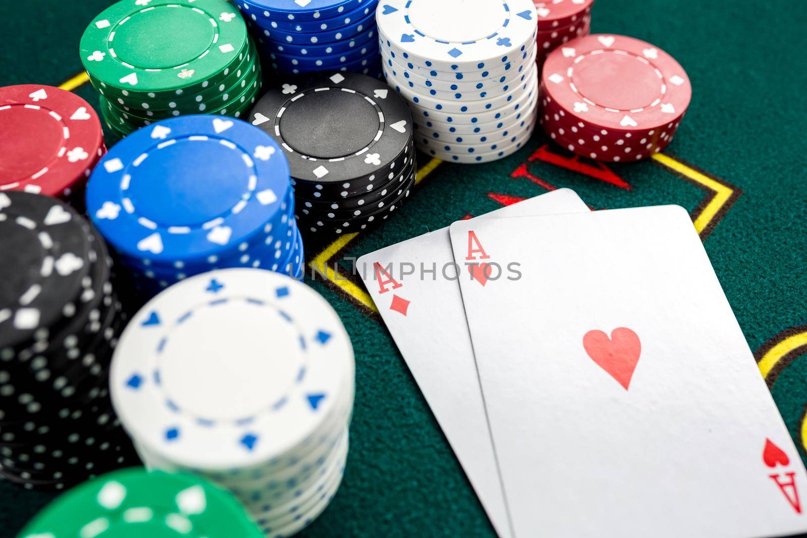 Poker play. Chips and cards on the green table