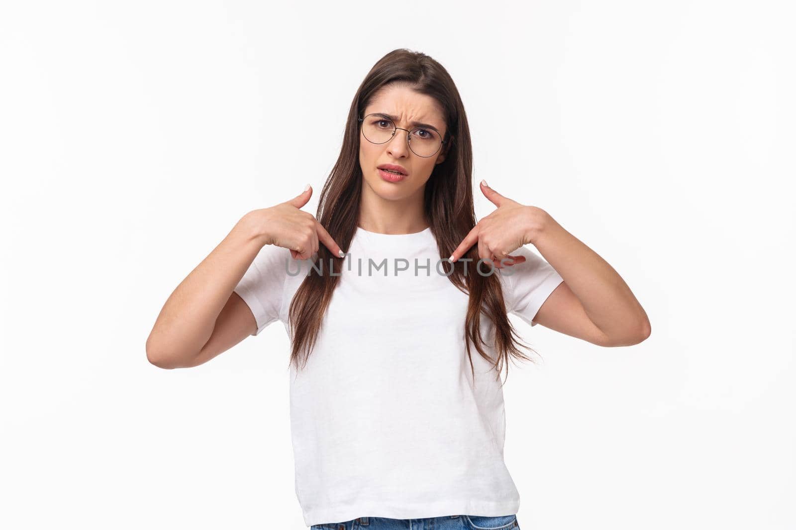 Waist-up portrait of insulted, shocked and offended young frustrated woman pointing at herself, grimace puzzled and confused, cant understand why she was picked or accused.