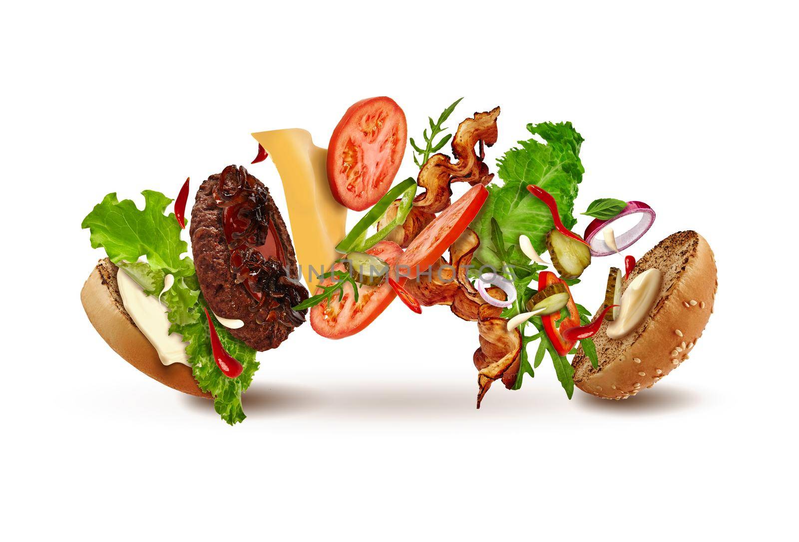 Delicious burger with flying ingredients isolated on white background. Ham, beef cutlet, cheese, mayonnaise, ketchup, vegetables and greens. Cooking, fast food. Close up, copy space