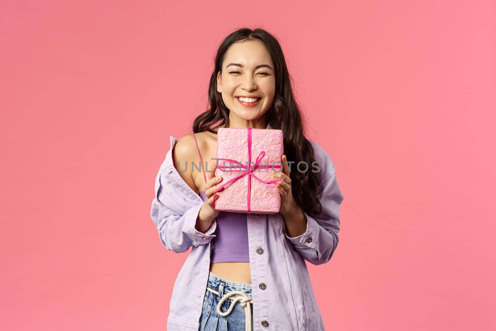 Portrait of cheerful, happy asian girl receive gift, smiling excited, holding wrapped present and cant hide happiness, celebrating birthday, being invited to b-day party, pink background by Benzoix