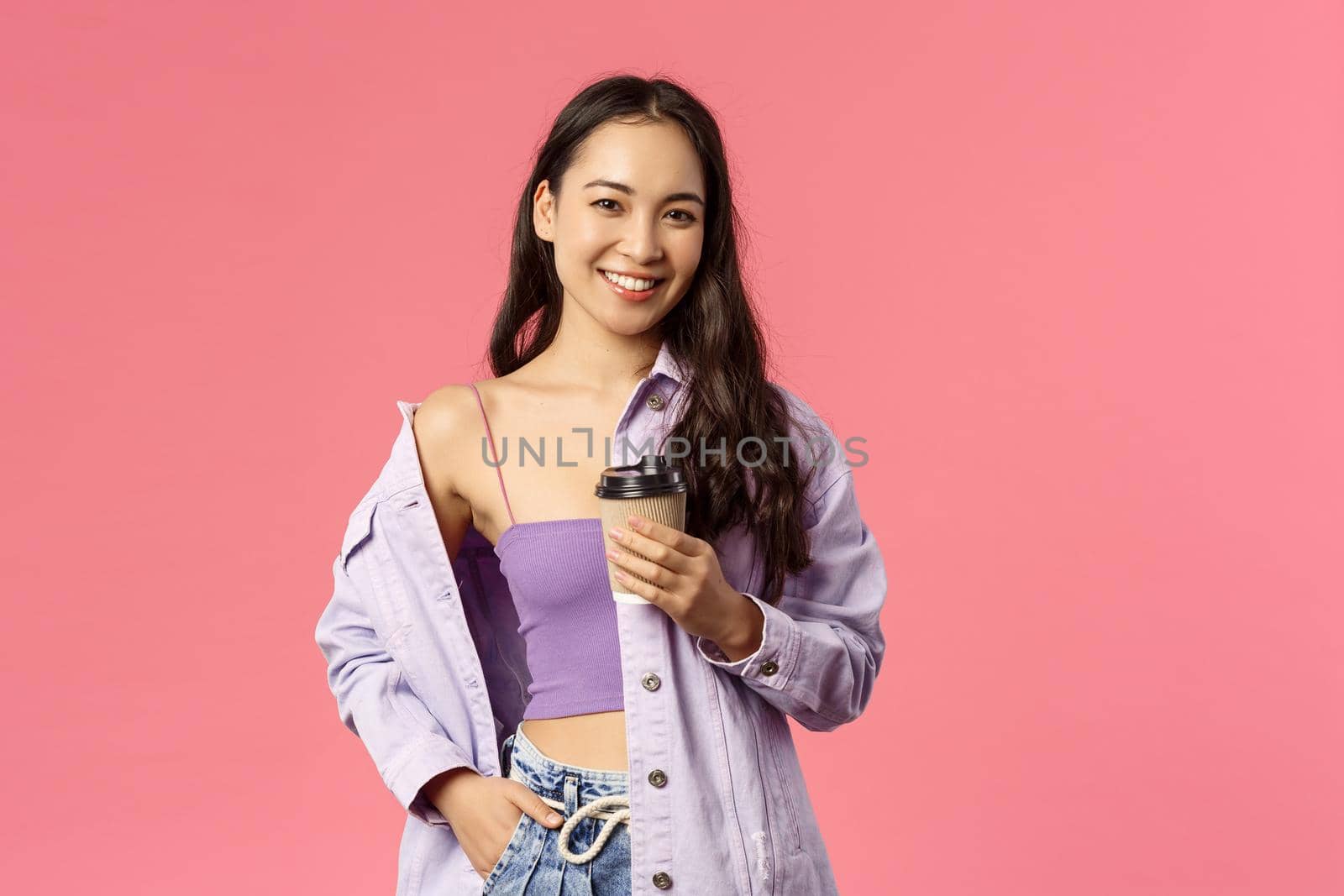 Lifestyle, modern people and beauty concept. Sassy good-looking asian girl chilling with friends at favorite cafe, grab take-away beverage, drinking coffee and smiling camera, pink background by Benzoix