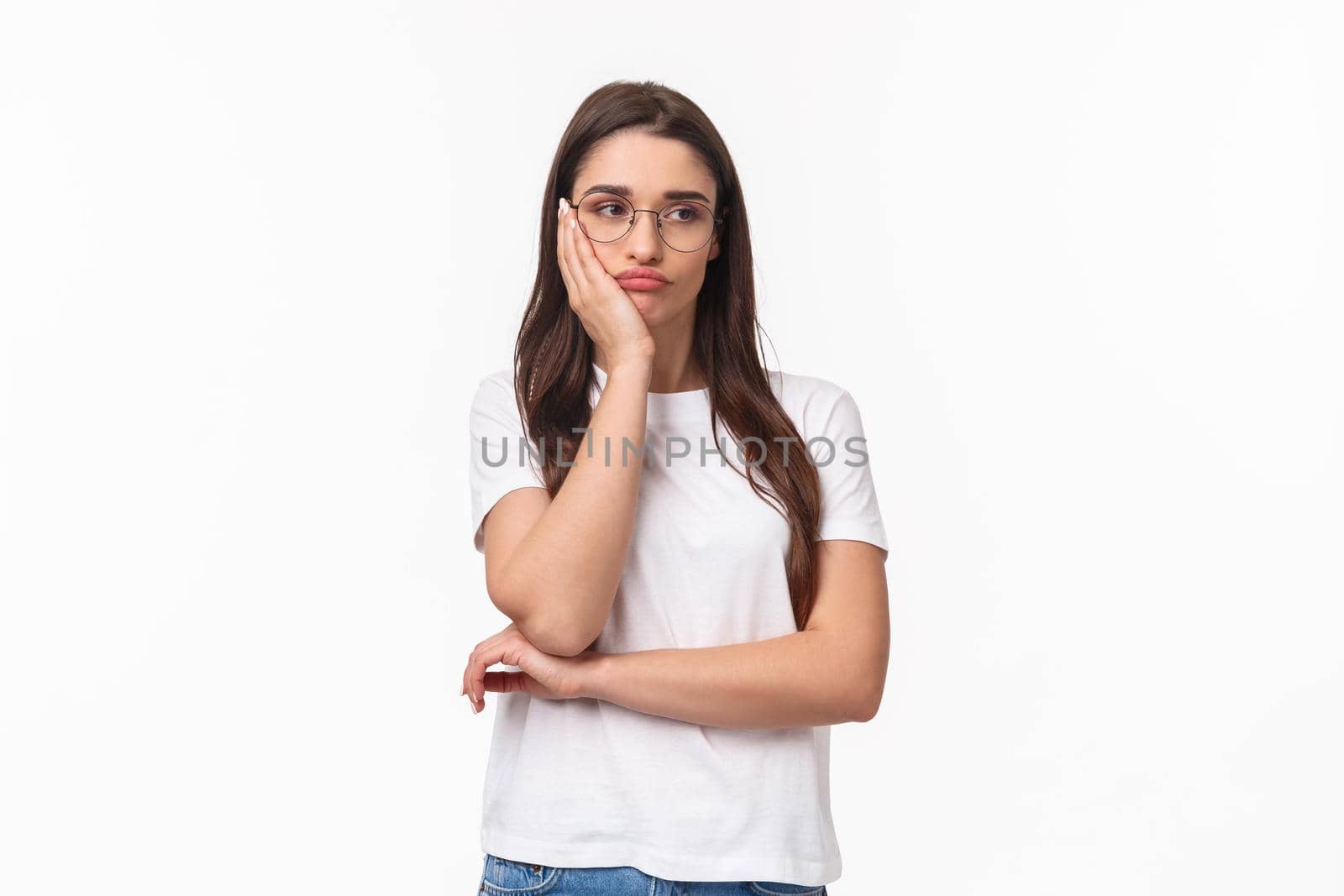 Portrait of bored and uninterested young reluctant girl, listening to boring talks, feel annoyed and unimpressed, lean on palm gloomy looking away, dream be anywhere else, white background.