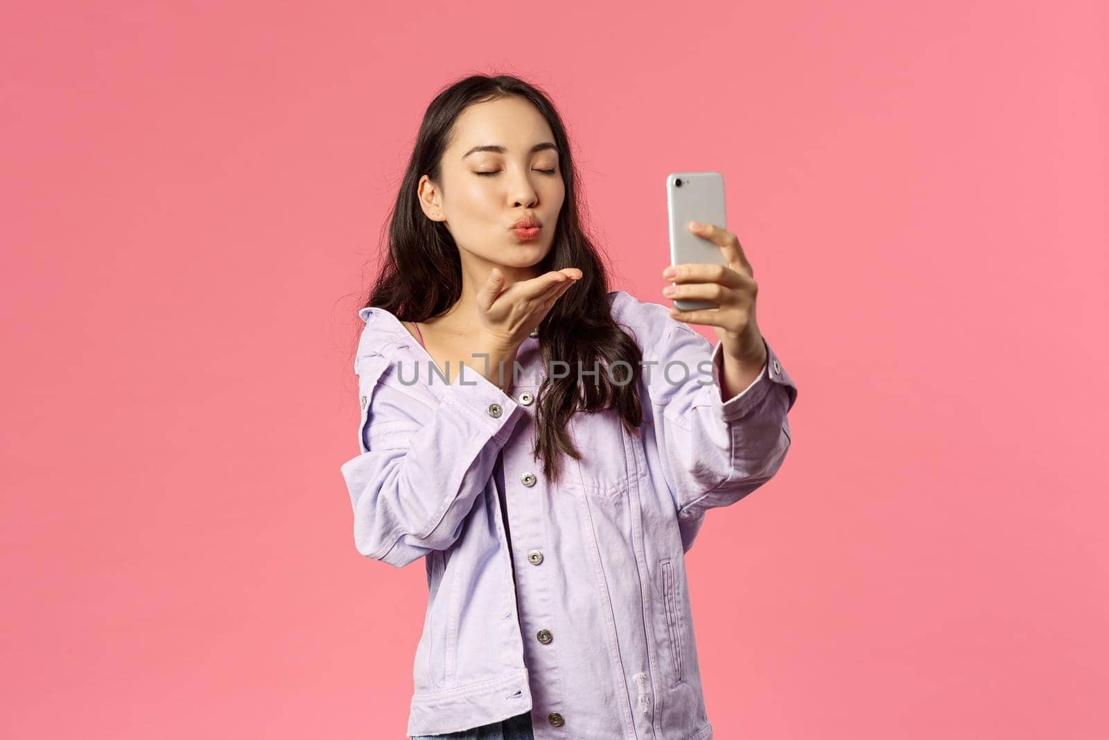 Online lifestyle, people and beauty concept. Portrait of romantic attractive young asian girlfriend cant be together with partner but send air kiss via video call, record video or selfie, blow mwah.