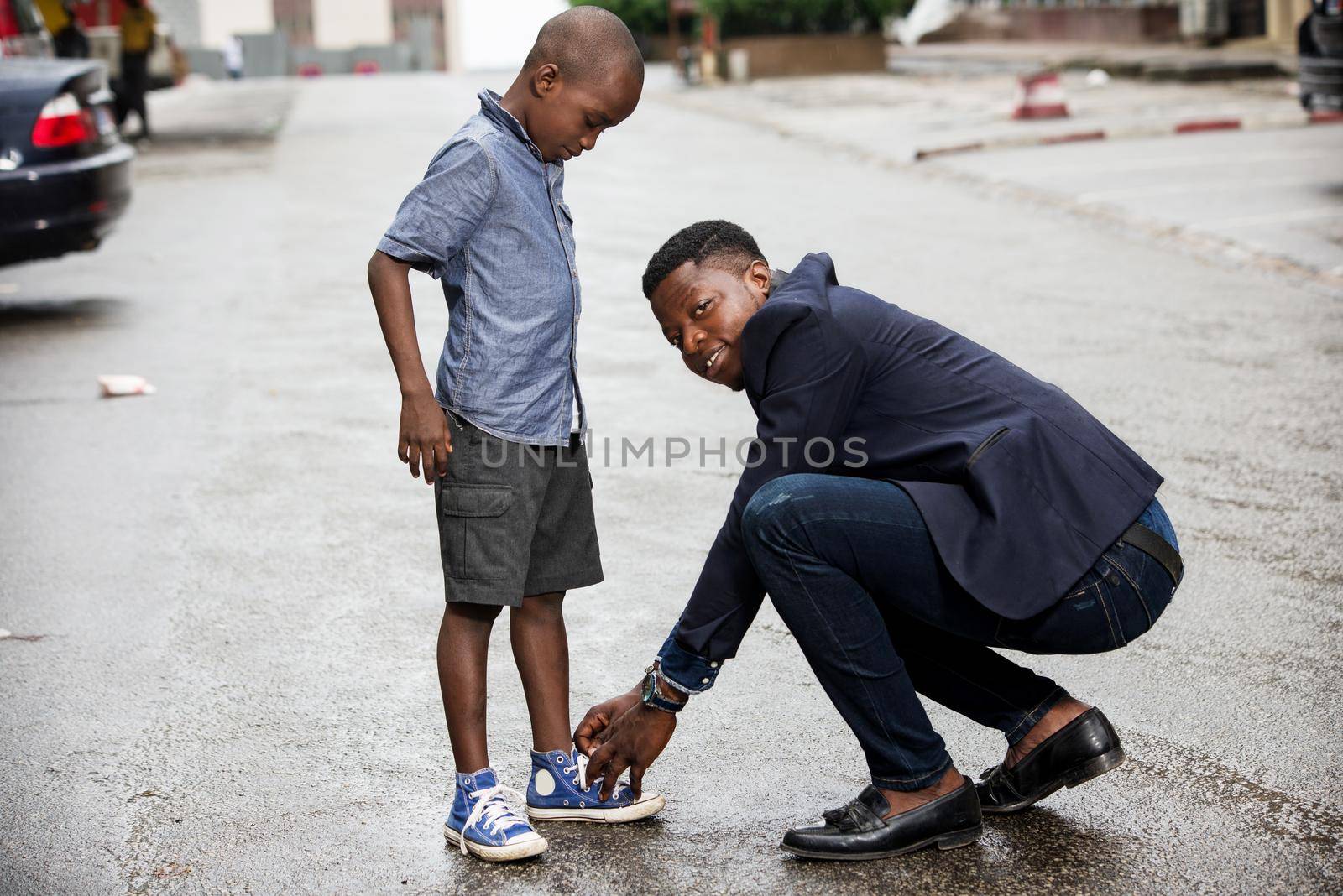 young man in costume putting on his child and looking at the camera smiling.