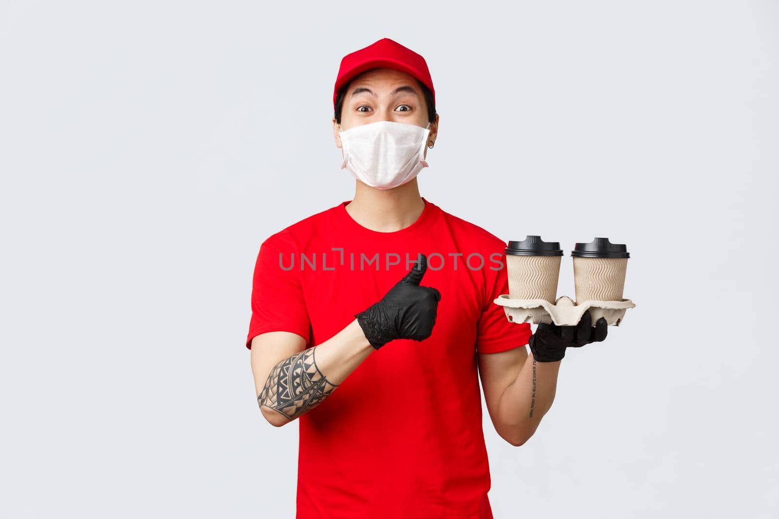 Your order is ready, best coffee in town. Smiling cheerful asian delivery man show thumb-up, deliver drinks to your house during pandemic covid 19, stay safe home and order online, recommend service.