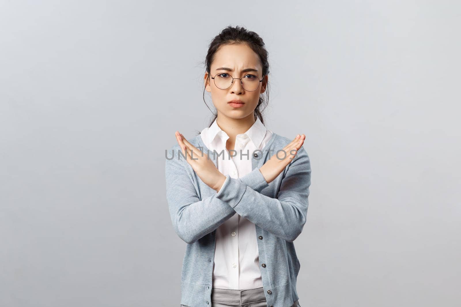 We must end it. Serious-looking determined young confident asian woman, making cross stop sign and looking concerned camera, prohibit something, disagree, trying restrict from going outside by Benzoix