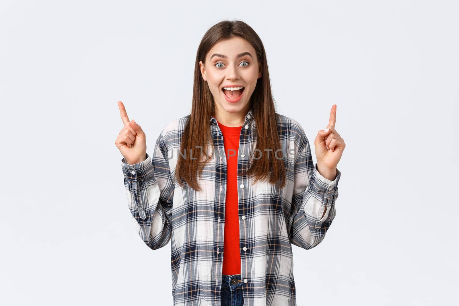 Lifestyle, different emotions, leisure activities concept. Smiling happy attractive woman in casual outfit inform about new summer prices, pointing fingers up special discount, white background.