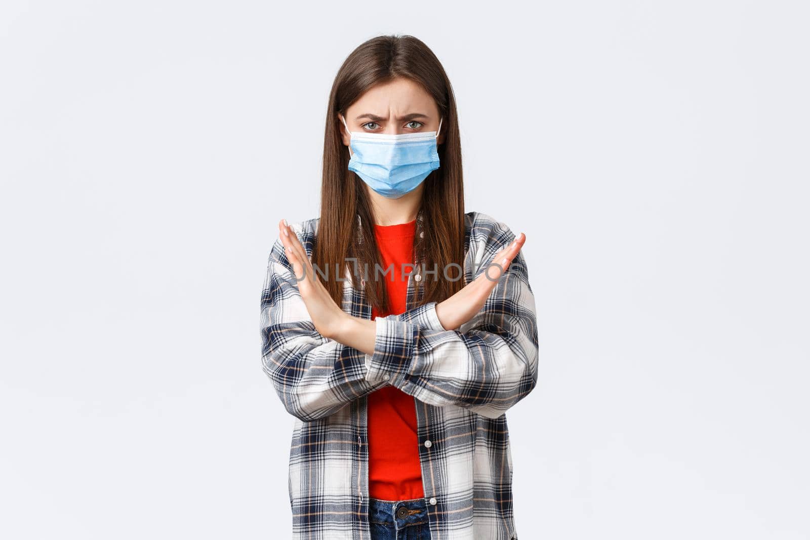 Coronavirus outbreak, leisure on quarantine, social distancing and emotions concept. Enough, this should stop. Serious displeased young woman in medical mask protest, show cross sign by Benzoix