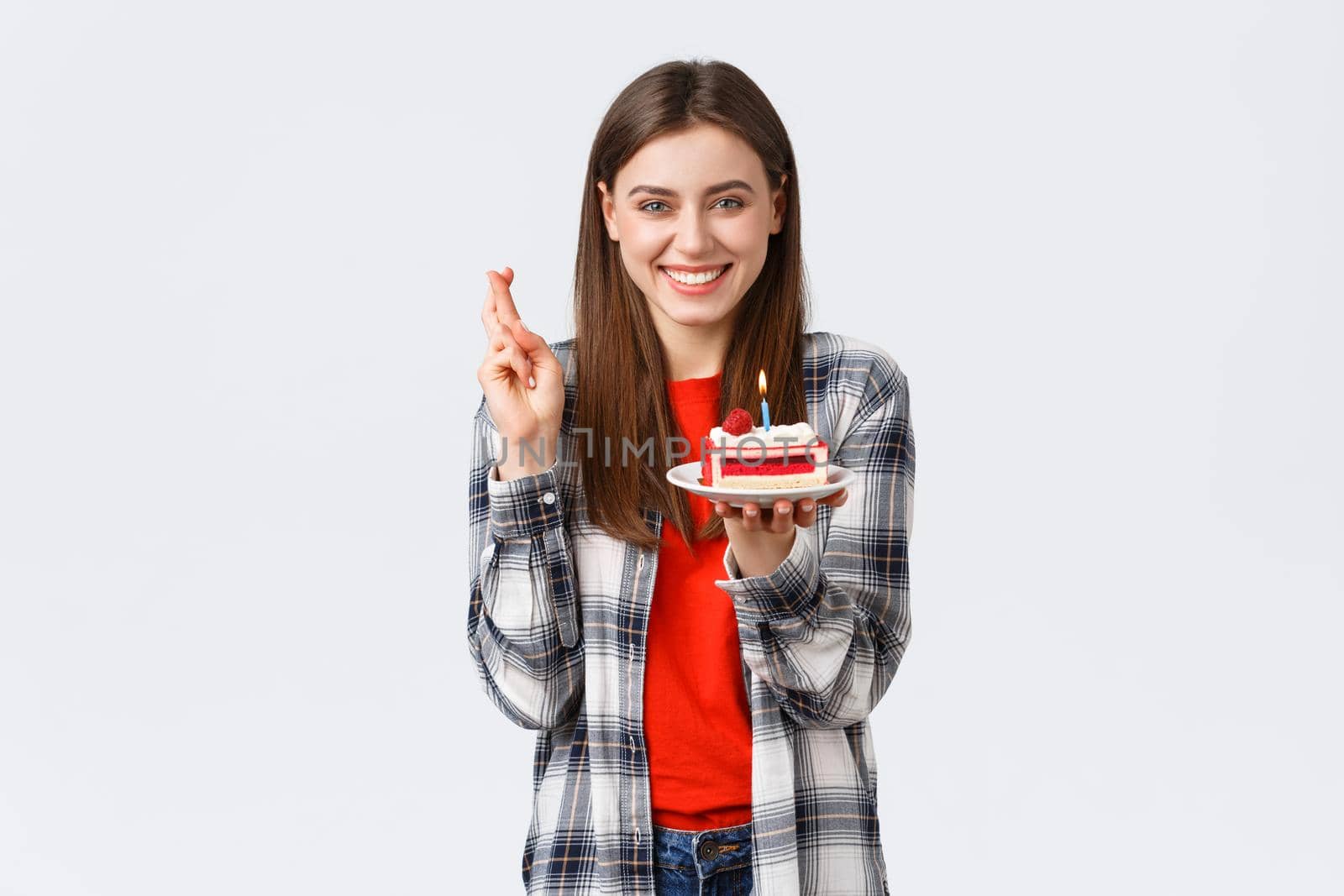 People lifestyle, holidays and celebration, emotions concept. Happy smiling pretty girl celebrate birthday, cross fingers good luck, blowing candle on b-day cake, having fun.