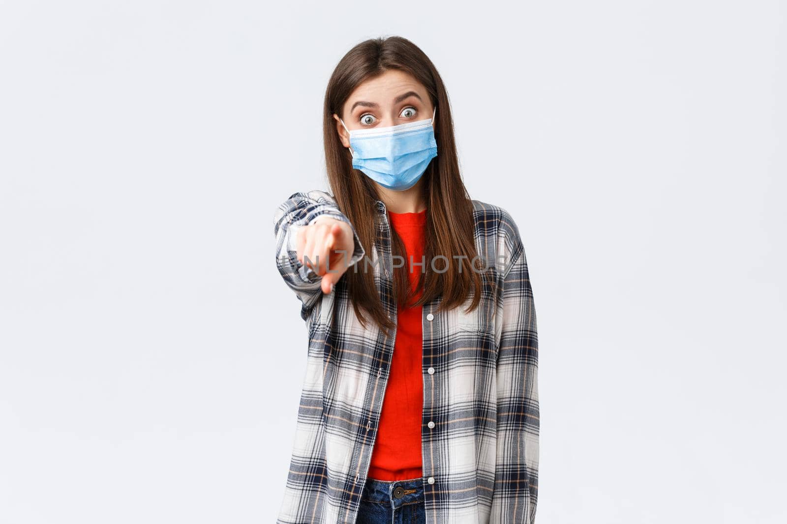 Coronavirus outbreak, leisure on quarantine, social distancing and emotions concept. Astonished and impressed, excited girl recognize someone, pointing finger camera, wear medical mask by Benzoix