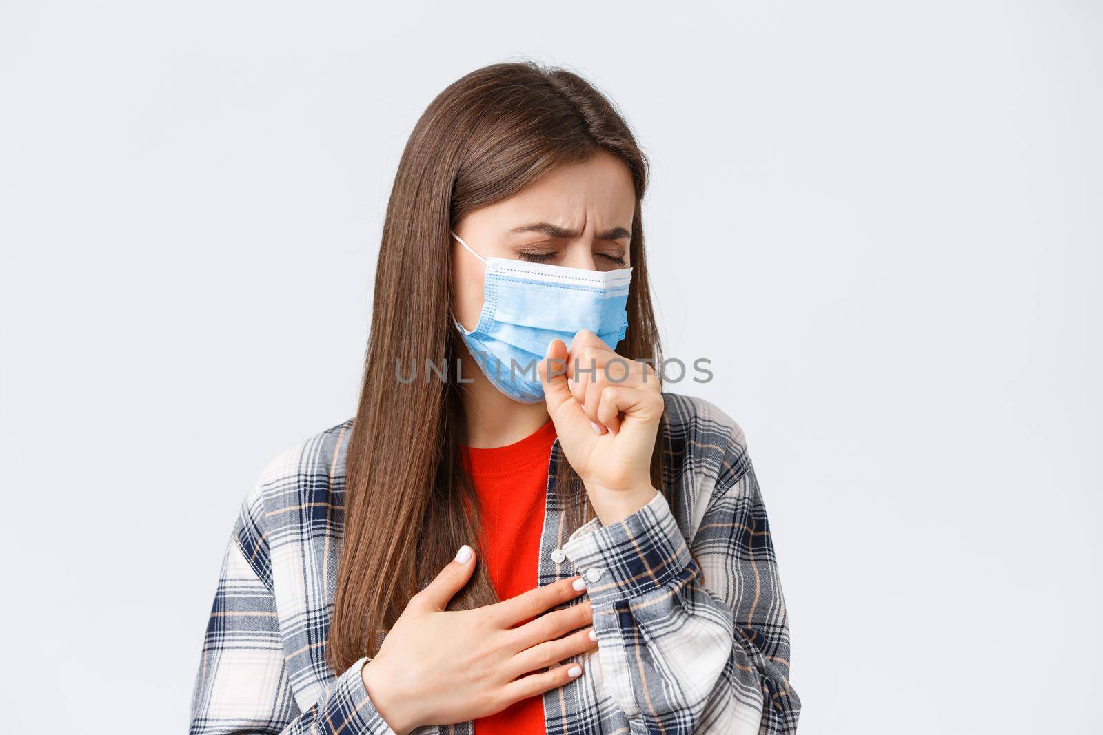 Coronavirus outbreak, leisure on quarantine, social distancing and emotions concept. Close-up of sick young woman in medical mask staying at home during covid-19, cough with closed eyes.