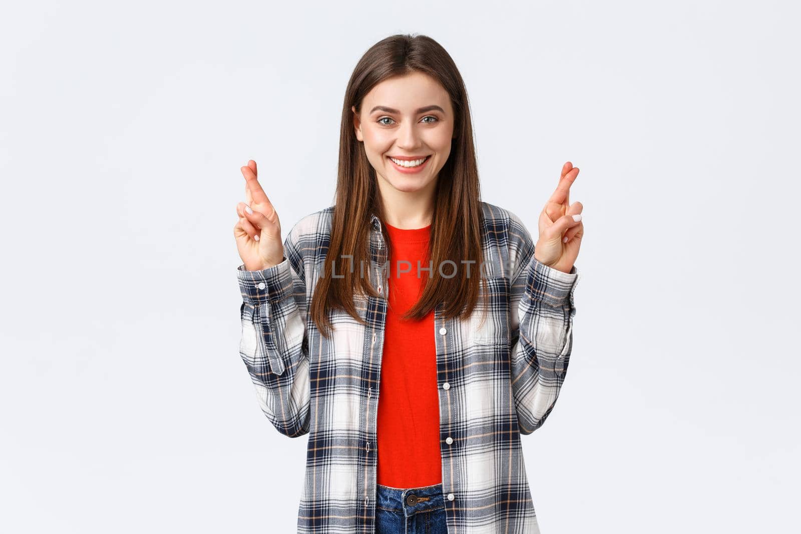 Lifestyle, different emotions, leisure activities concept. Hopeful cute caucasian girl in checked shirt, making wish, cross fingers good luck and smiling optimistic, white background by Benzoix