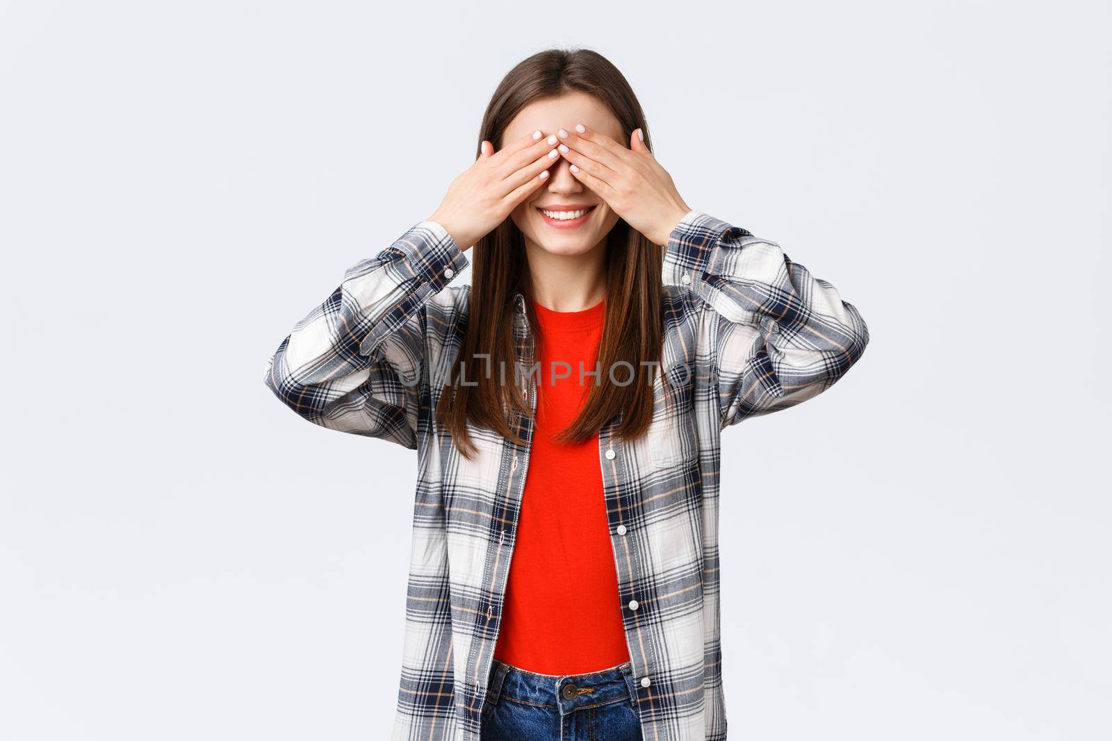 Lifestyle, different emotions, leisure activities concept. Excited happy young relaxed girl promise not peek. Woman cover eyes with palms, playing hide n seek or waiting for surprise.