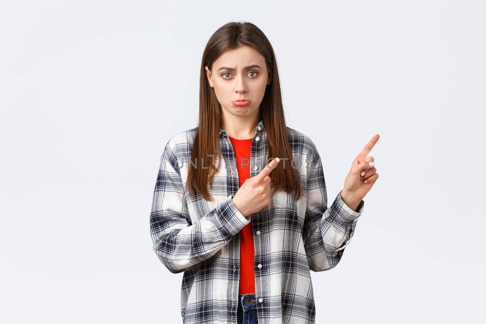 Lifestyle, different emotions, leisure activities concept. Gloomy cute girlfriend or daughter begging for something, pointing finger right with sulking face, express regret, wishing have this thing by Benzoix