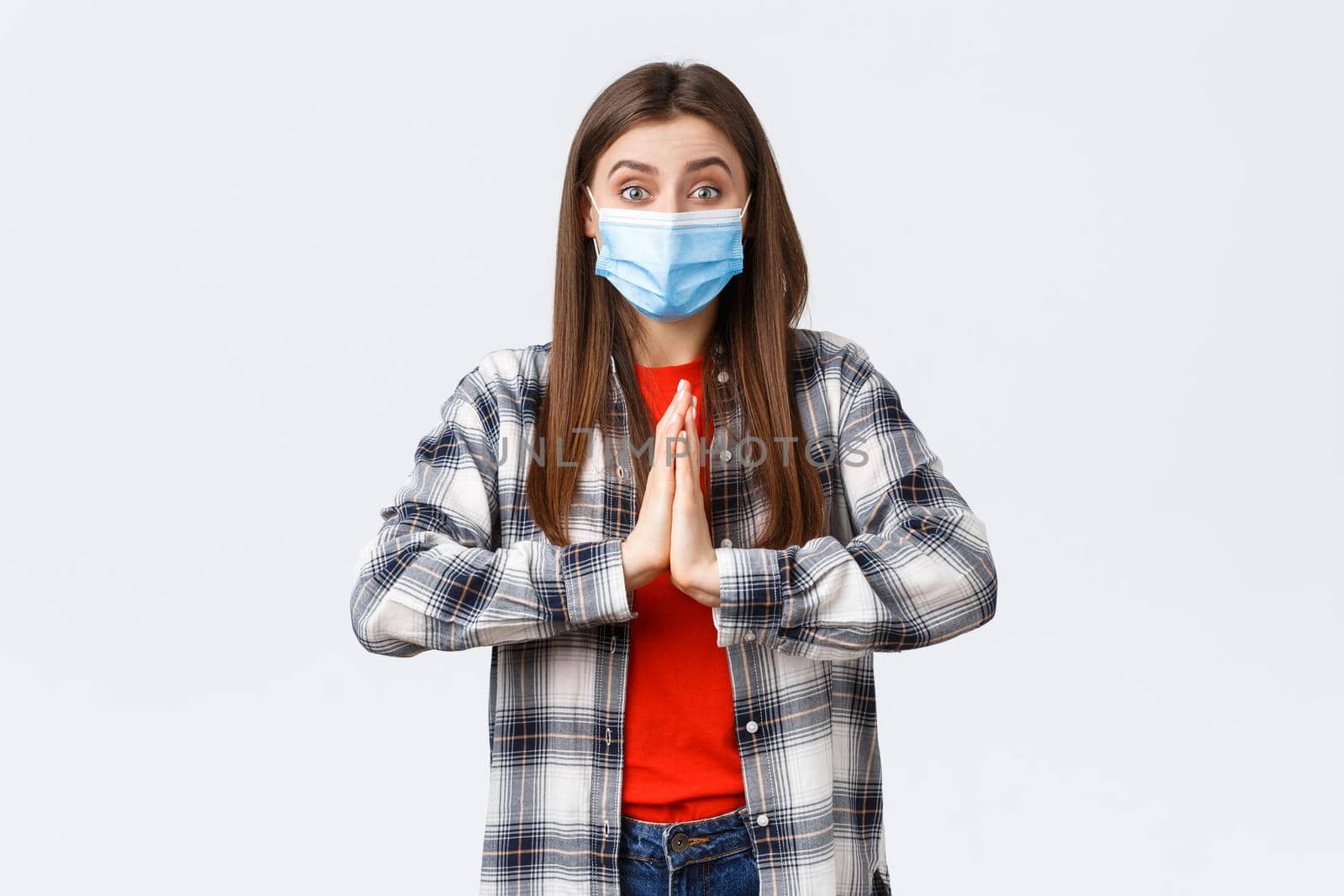 Different emotions, covid-19 pandemic, coronavirus self-quarantine and social distancing concept. Hopeful enthusisatic girl, volunteer in medical mask, asking please, begging help, hold hands in pray.